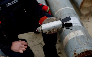 A defused cluster bomb from an MSLR missile among a display of pieces of rockets reportedly used by the Russian army in Kharkiv