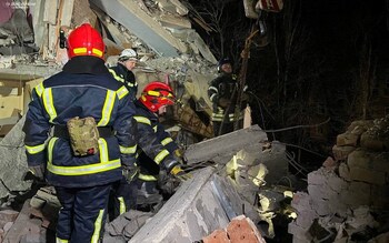 Rescuers work at a site of an apartment building damaged at night by Russian missile strike