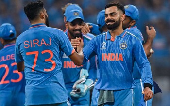 India's Virat Kohli celebrates with team-mate Mohammed Siraj (L) after winning the semi-final against New Zealand 