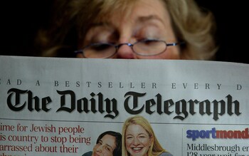 A commuter reading the Daily Telegraph Newspaper