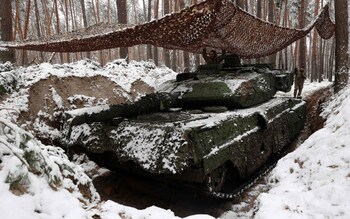 A Ukrainian tank crew stand in the turret of a snow-covered Leopard 2 tank in Donetsk